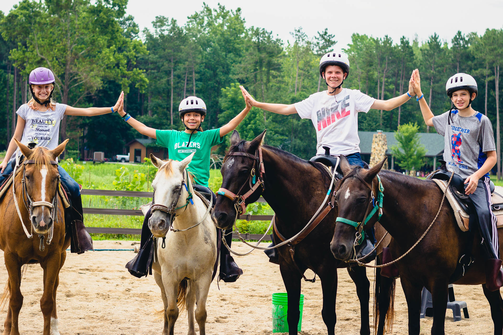 four children on horses with hair in the air touching