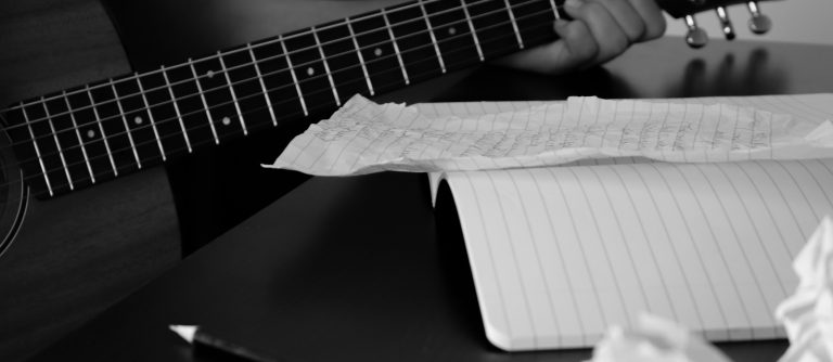 crumpled paper, notebook with someone playing guitar